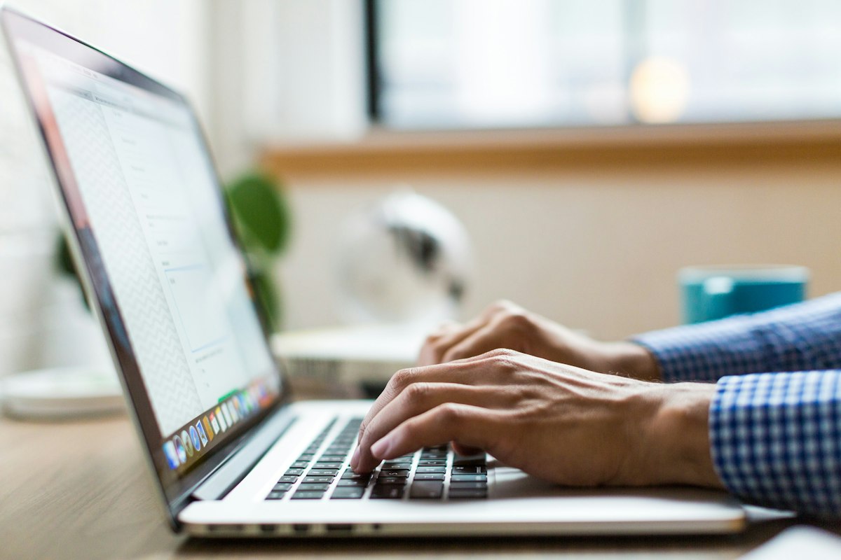 Person typing an email on a laptop